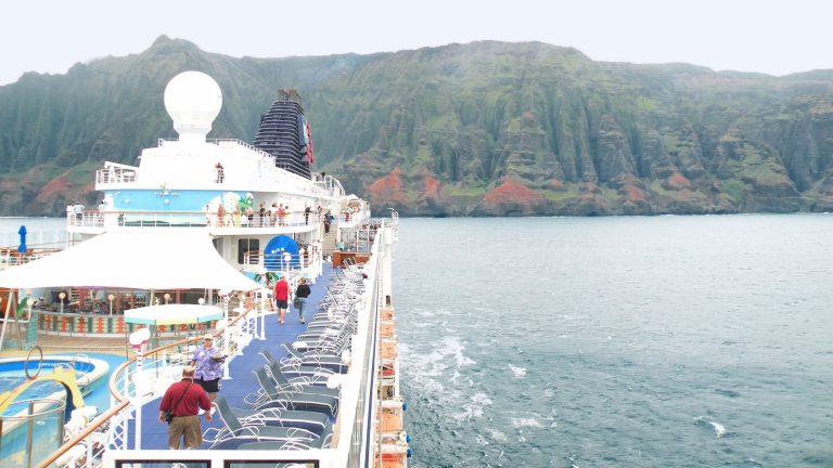 Airial photo of the top decks of a cruise ship under sail off the coast of one of the Hawaiian
